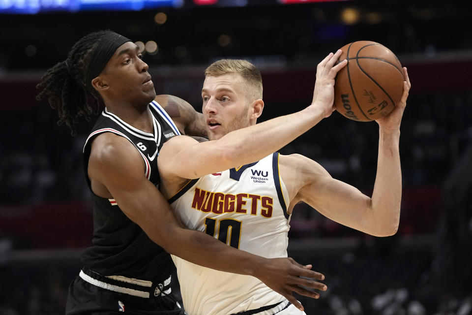 Denver Nuggets forward Jack White, right, tries to pass as Los Angeles Clippers guard Terance Mann reaches in during the second half of an NBA basketball game Friday, Nov. 25, 2022, in Los Angeles. (AP Photo/Mark J. Terrill)