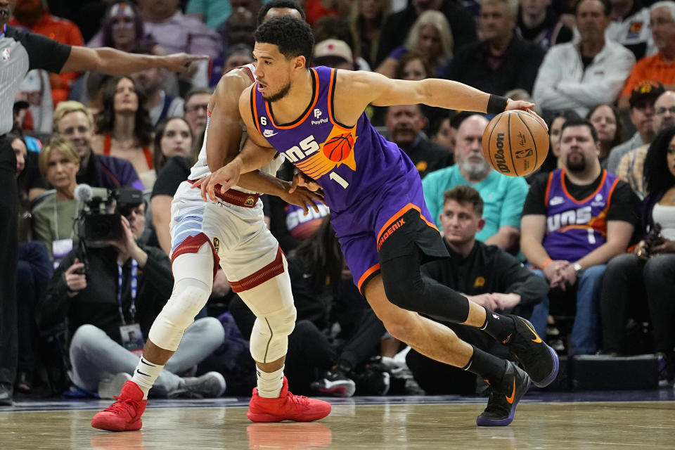 Phoenix Suns guard Devin Booker (1) drives against during the first half of an NBA basketball game, Friday, March 31, 2023, in Phoenix. (AP Photo/Matt York)