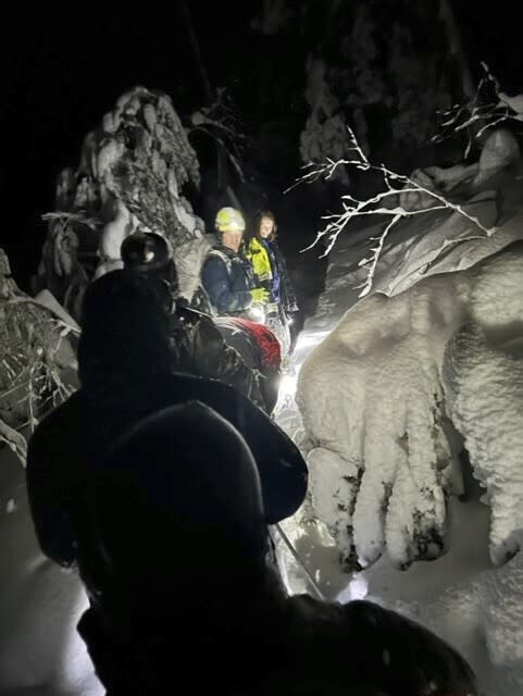 In this photo provided by Massachusetts State Police, a search team looks for two hikers stranded by heavy snow, on an overnight rescue operation, in Mount Washington State Forest in Massachusetts, early Wednesday, March 15, 2023. (Massachusetts State Police via AP)