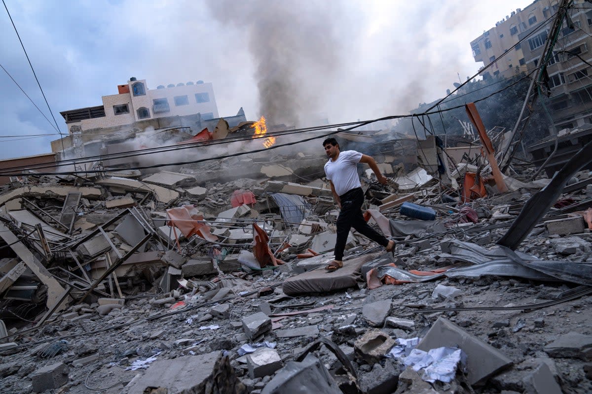 Palestinians walk amid the rubble following Israeli airstrikes in Gaza City  (Copyright 2023 The Associated Press. All rights reserved)