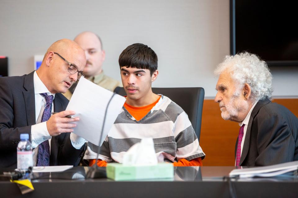 Romeo Perdomo, 17, speaks to his lawyers Trever Hook and William Kutmus during a hearing requesting that his case is moved to juvenile court, Monday, May 2, 2022. Perdomo is one of 10 youths charged in the March 7 fatal shooting outside East High in Des Moines.