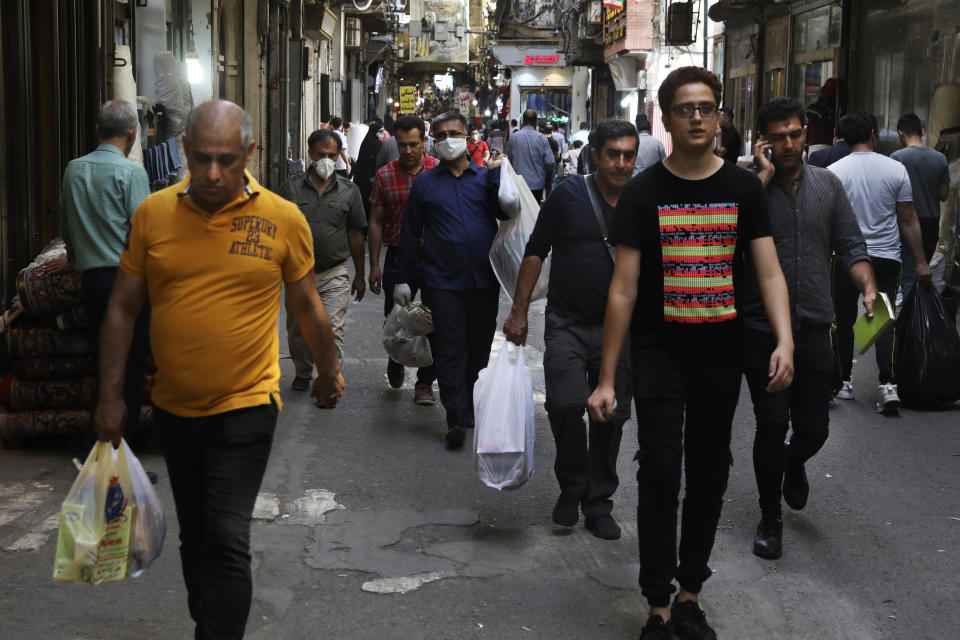 In this June 10, 2020, photo, people walk through Tehran's Grand Bazaar in Iran. As businesses open and people begin to move around more, health experts fear a growing complacency among Iran’s 80 million people may further allow the virus to spread. (AP Photo/Vahid Salemi)