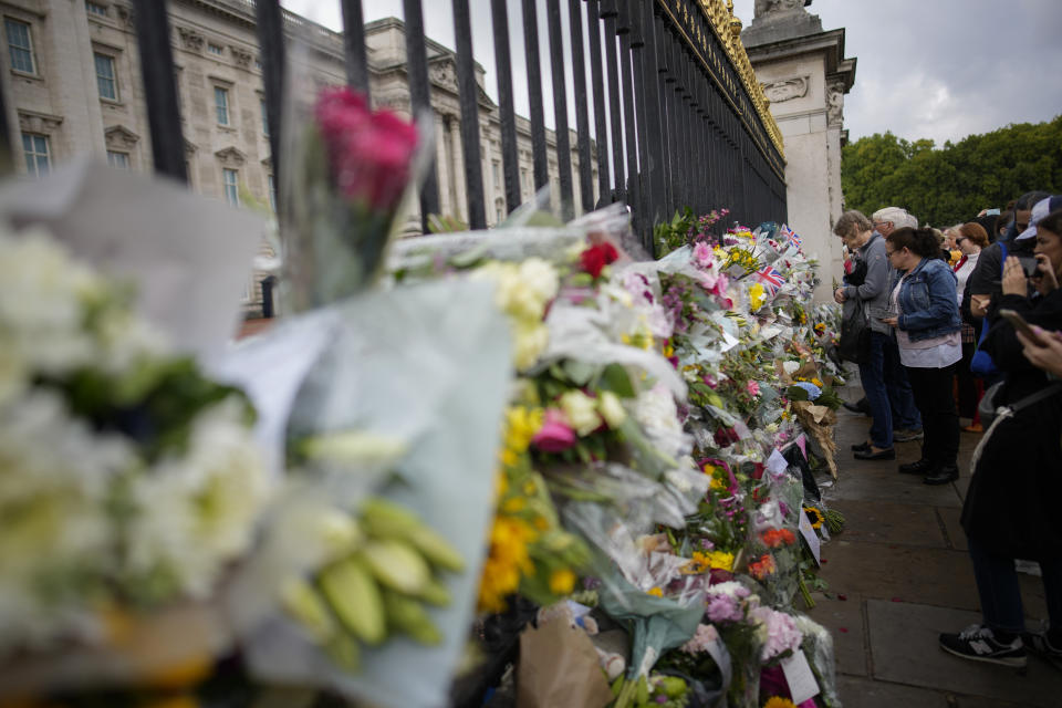 Dolientes reunidos fuera del Palacio de Buckingham para rendir homenaje a la reina en Londres el 9 de septiembre de 2022. La reina Isabel II, la monarca con el reinado más largo de Gran Bretaña y una roca de estabilidad en buena parte de un siglo turbulento, falleció el jueves 8 de septiembre de 2022 tras 70 años en el trono. Tenía 96 años. (Foto AP/Christophe Ena)