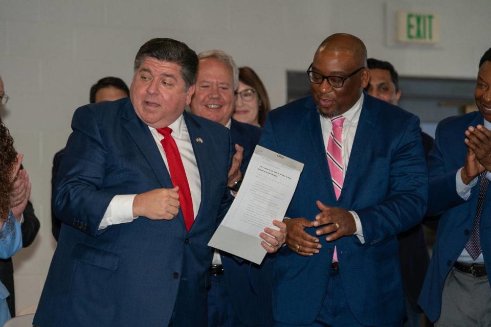 Gov. J.B. Pfitzker and Illinois state representatives Chris Belt and Jay Hoffman celebrate Friday’s signing of a bill granting roughly $20 million to combat food deserts in rural, urban and suburban communities.