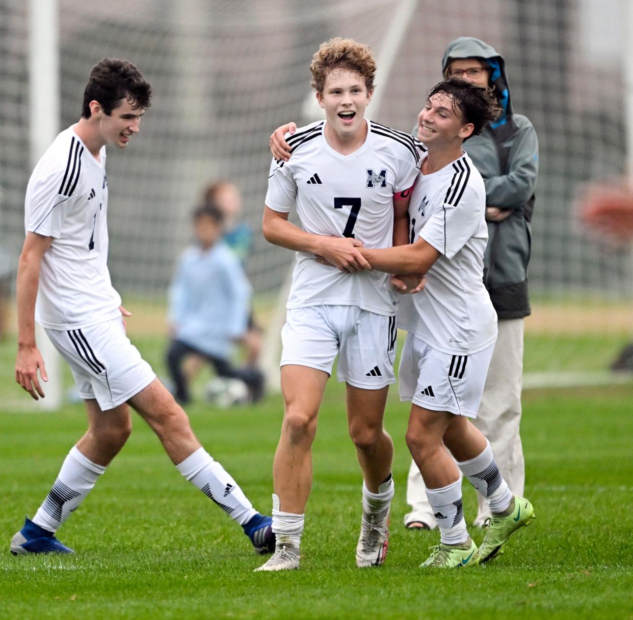 Ryan Laramee (center) is joined by his Monomoy teammates Greg Greiner (right) and Stephen Kelly after scoring his second and winning goal against Dennis-Yarmouth.
