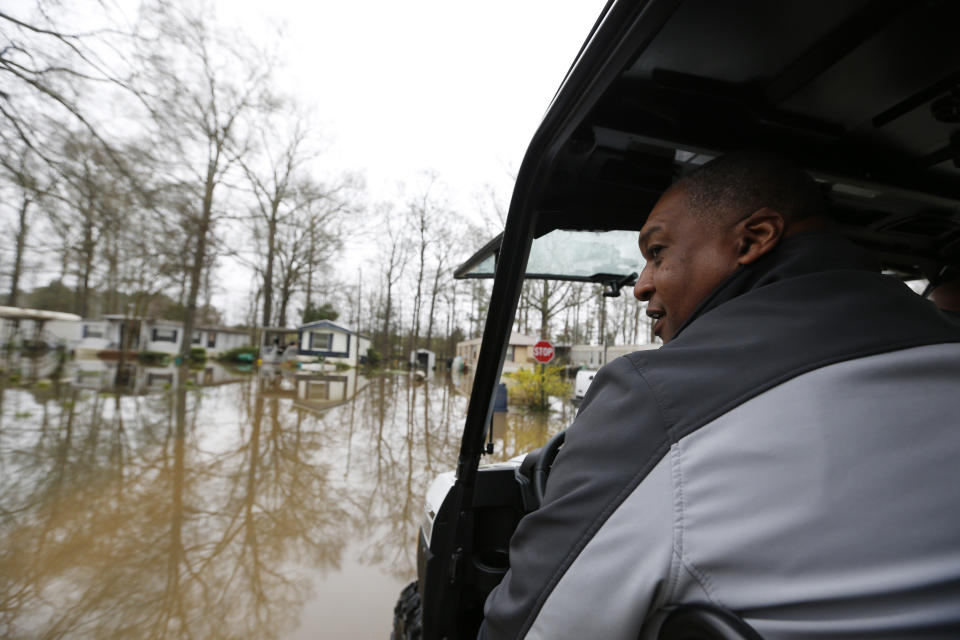 Ridgeland assistant chief of police Eric Redd looks out at the standing floodwater from the Pearl River that surrounds a number of mobile homes in the Harbor Pines community in Ridgeland, Miss., Tuesday, Feb. 18, 2020. While much of the water in the community receded overnight, there are areas that still have high water. (AP Photo/Rogelio V. Solis)