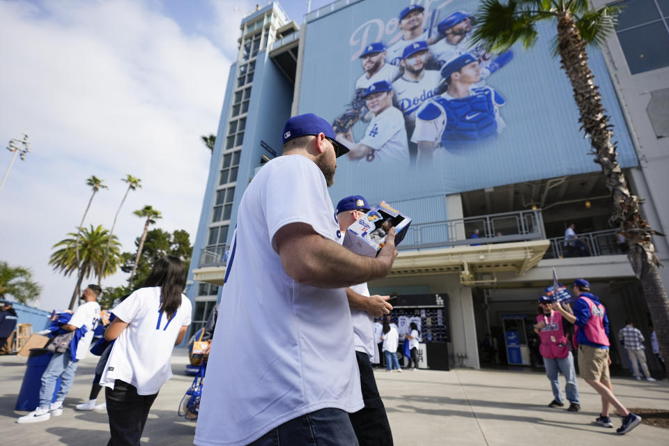 Fans carry bobbleheads of Los Angeles Dodgers designated hitter Shohei Ohtani before a baseball game against the Cincinnati Reds in Los Angeles, Thursday, May 16, 2024. (AP Photo/Ashley Landis)