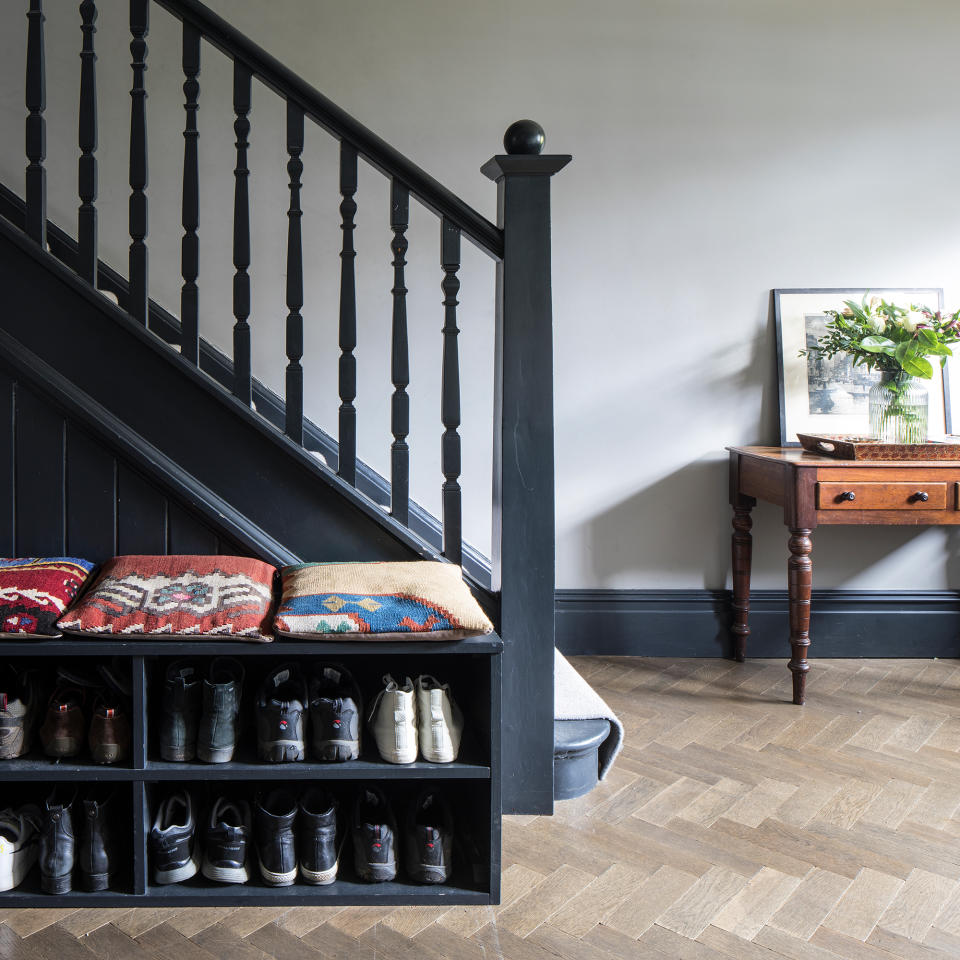 hallway with dark grey woodwork and grey walls with shoe storage