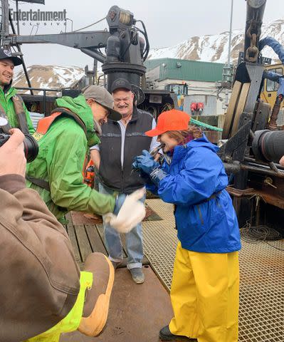 <p>Original Productions/Discovery Channel</p> 'Wizard' crew and Captain Keith Colburn cheer me on as I rip the herring in two.