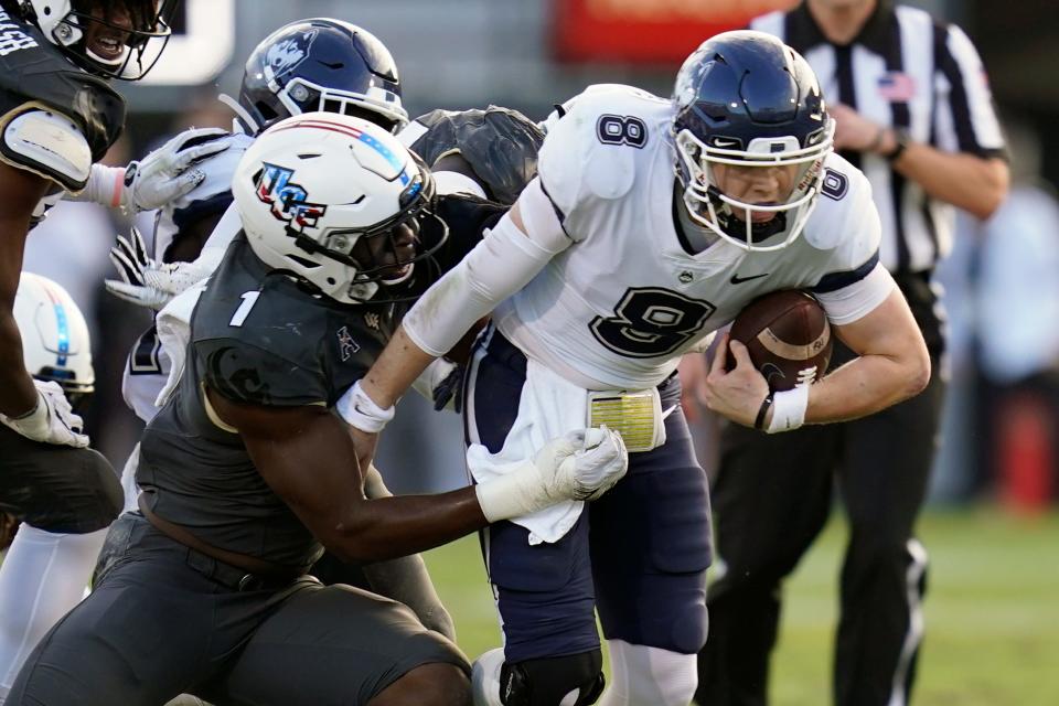 Central Florida defensive lineman Big Kat Bryant (1) sacks Connecticut quarterback Steven Krajewski (8) during the first half of an NCAA college football game, Saturday, Nov. 20, 2021, in Orlando, Fla. (AP Photo/John Raoux)