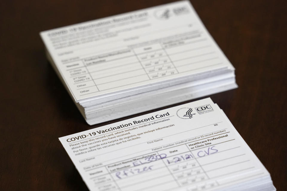 Vaccination record cards are shown before residents are inoculated, Thursday, Jan. 21, 2021, at the Isles of Vero Beach assisted and independent senior living community in Vero Beach, Fla. The government tasked CVS and Walgreens with administering the shots to long-term care locations in nearly every state. (AP Photo/Wilfredo Lee)