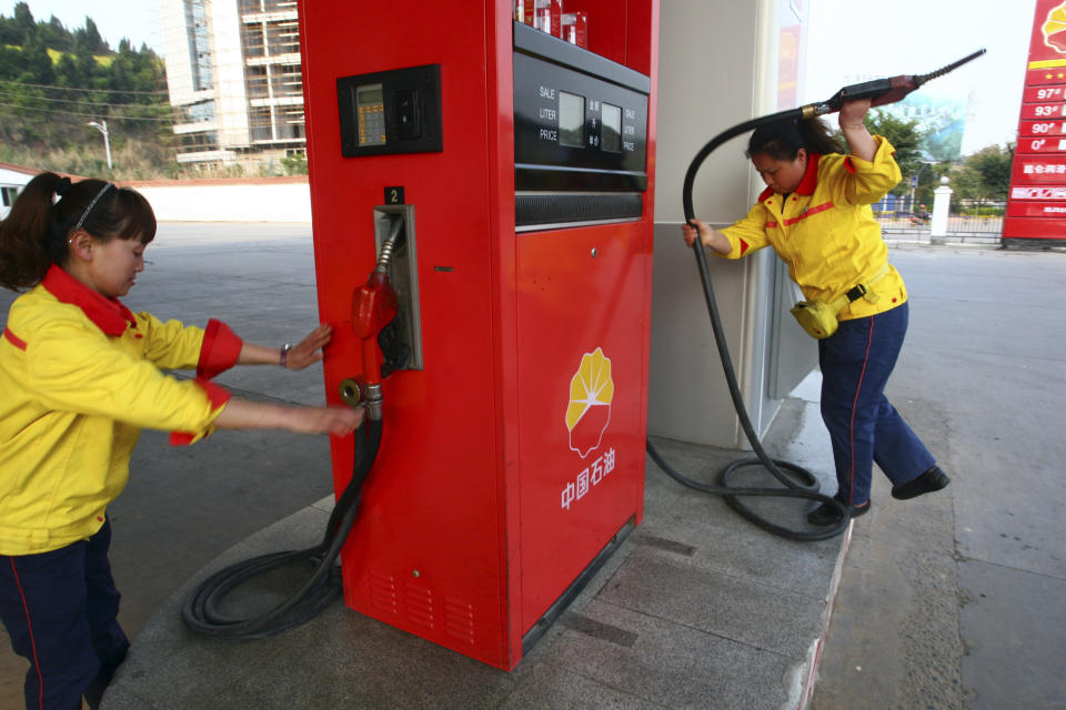 FILE - In this March 26, 2012, file photo, workers operate the pumps at a PetroChina gas station in Suining in southwestern China's Sichuan province. Profit at state-owned companies that dominate China's banking, oil and most other industries rose by as much as 25% in 2020 as the country recovered from the coronavirus pandemic, according to the. State-Owned Assets Supervision and Administration Commission which oversees 97 companies directly under the Cabinet including PetroChina Ltd., Asia's biggest oil producer; China Mobile Ltd., the world's biggest phone carrier by number of subscribers, and Industrial and Commercial Bank of China Ltd., the world's biggest bank by assets. (AP Photo, File)