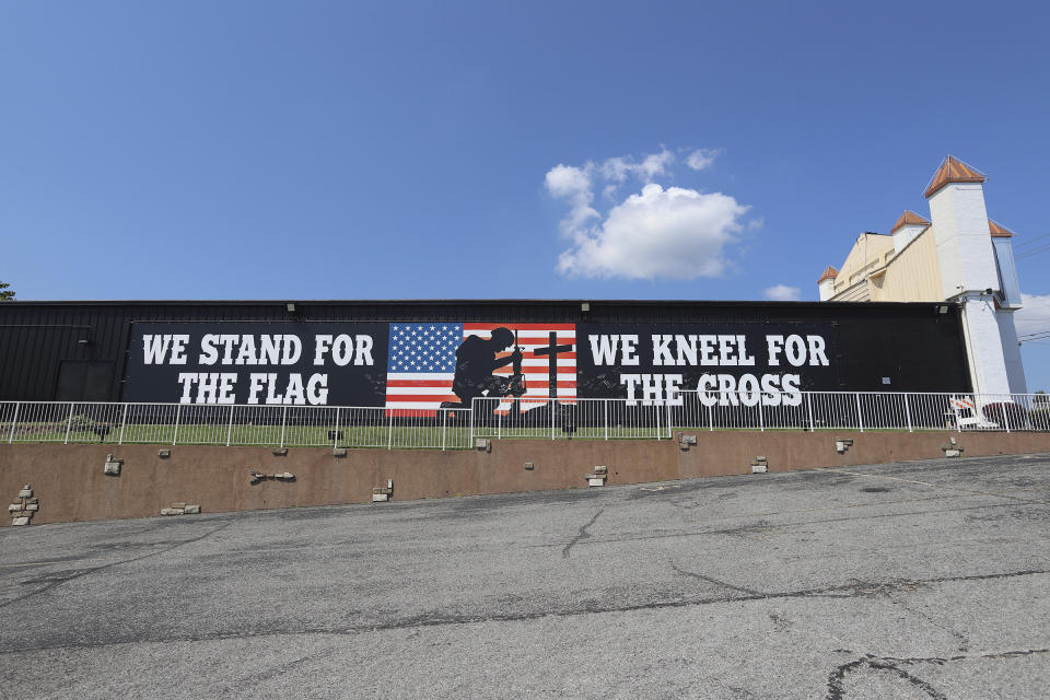 A large sign reading "We stand for the flag. We kneel for the cross." covers the side of the Pierce Arrow Theater in Branson, Mo., on Aug. 26, 2022. (Kit Doyle/RNS via AP)