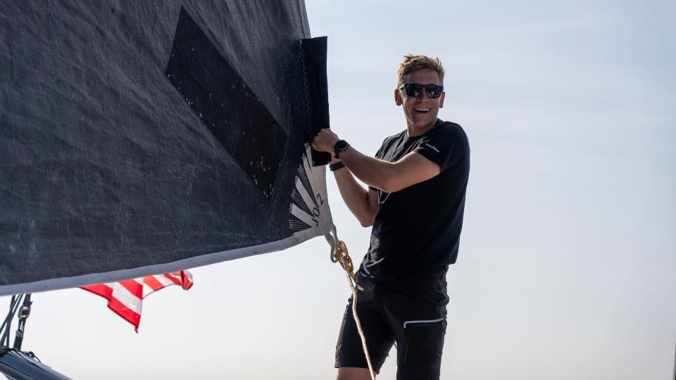 Will Harris adjusting the sail of the J2 during a boat delivery.