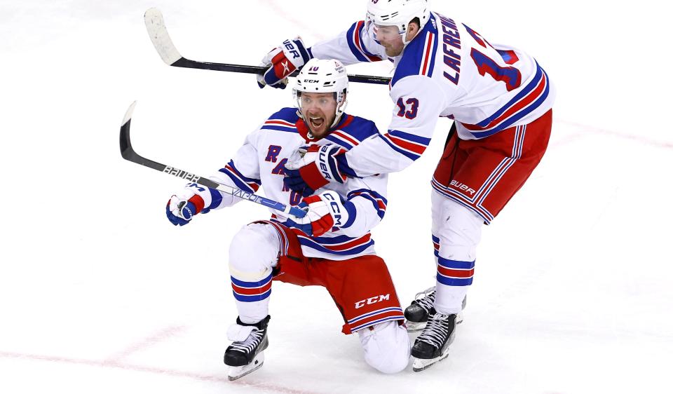 New York Rangers left wing Artemi Panarin (10) celebrates with Alexis Lafreniere (13) after his goal against the New Jersey Devils during the third period of an NHL hockey game Saturday, Nov. 18, 2023, in Newark, N.J.
