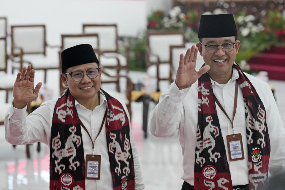 Presidential candidate Anies Baswedan, right, and his running mate Muhaimin Iskandar wave at the media upon arrival to register themselves to run in next year's election at the General Election Commission building in Jakarta, Indonesia, Thursday, Oct. 19, 2023. The world's third-largest democracy is set to vote in simultaneously legislative and presidential elections on Feb. 14, 2024. The country has had free and largely peaceful elections since the fall of dictator Suharto in 1998. (AP Photo/Tatan Syuflana)