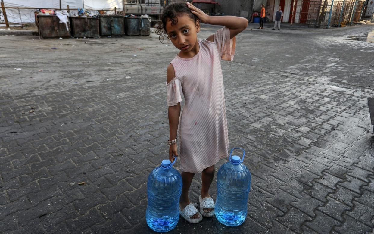 A Palestinian child with two bottles of water