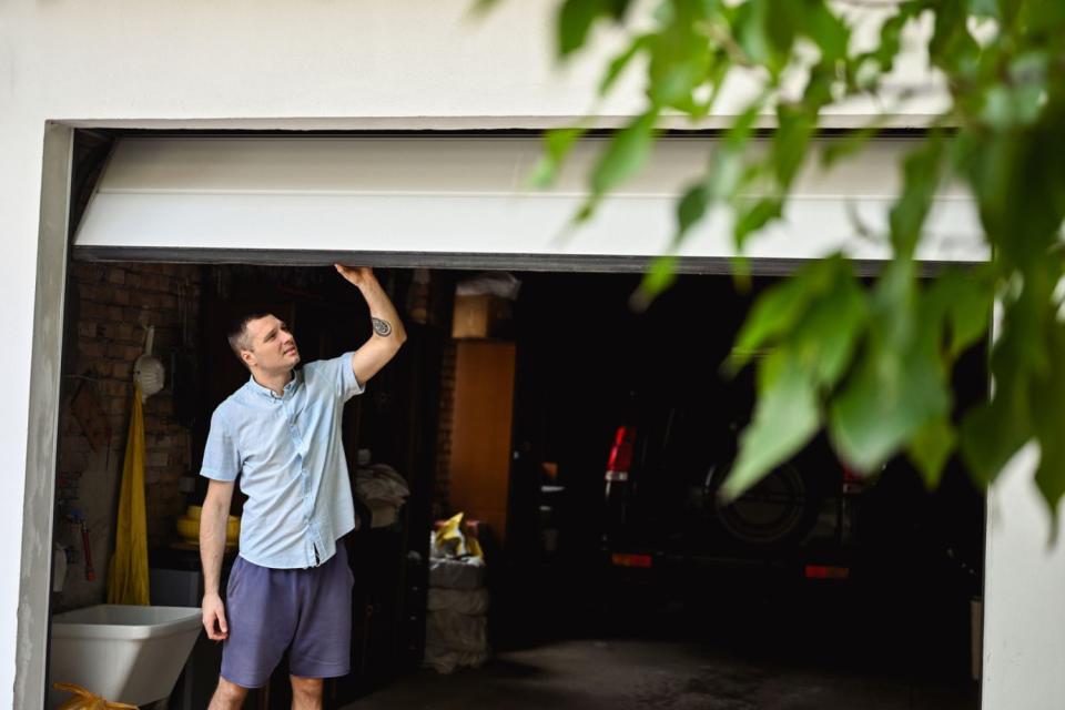 A person lifts a white garage door.