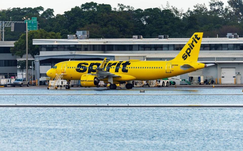 A Spirit Airlines airplane parked as the runway remains flooded from heavy rain at Fort Lauderdale-Hollywood International Airport on Thursday, April 13, 2023.