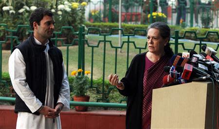 Chief of India's ruling Congress party Sonia Gandhi (R) speaks as her son, lawmaker Rahul Gandhi, watches during a news conference in New Delhi December 8, 2013. REUTERS/Stringer