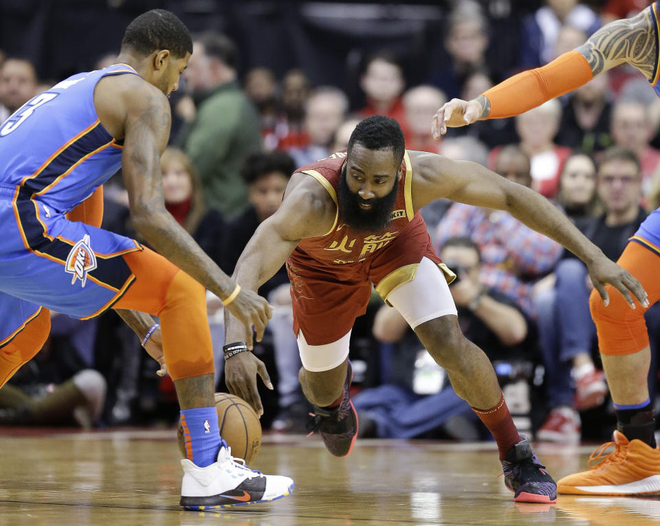 Houston Rockets guard James Harden, right, and Oklahoma City Thunder forward Paul George reach for a loose ball during the first half of an NBA basketball game, Saturday, Feb. 9, 2019, in Houston. (AP Photo/Eric Christian Smith)