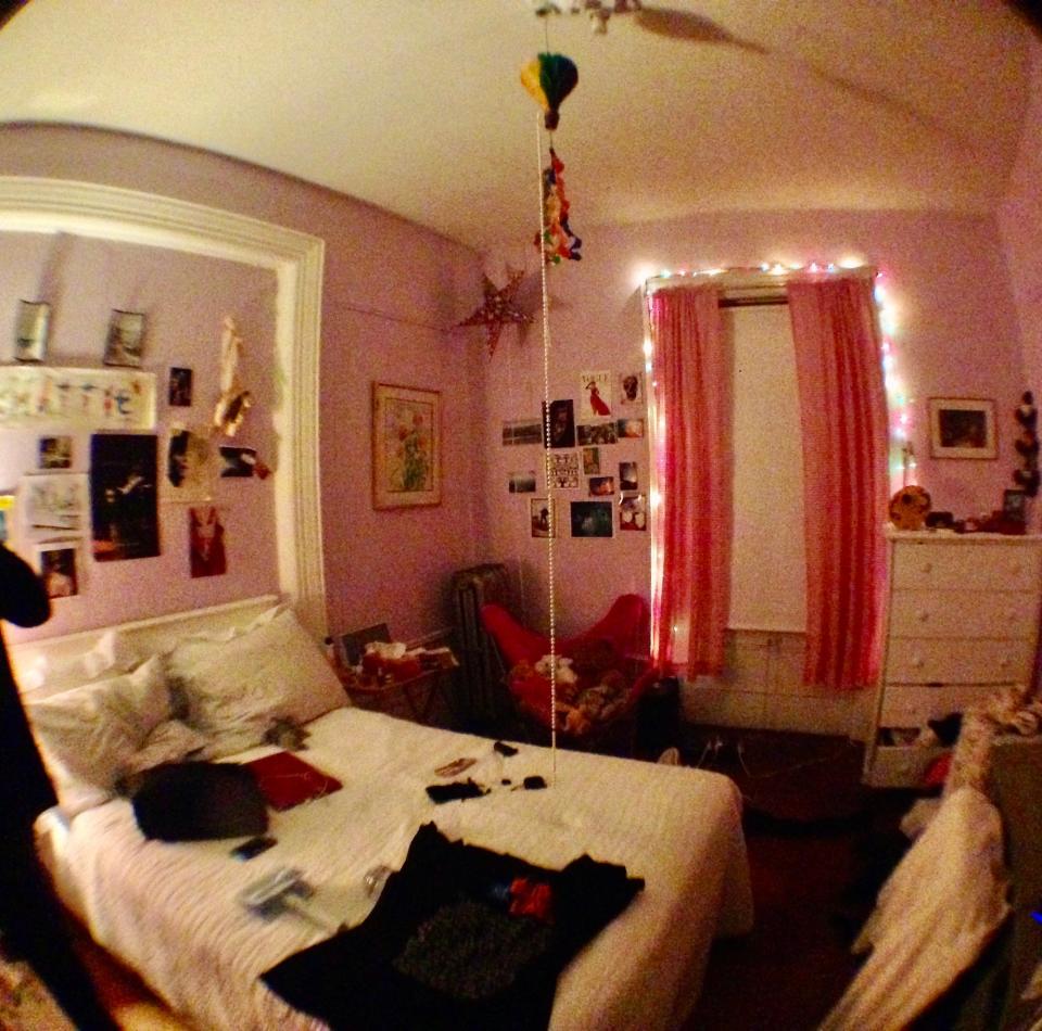 A bedroom with pink walls and pink curtains.