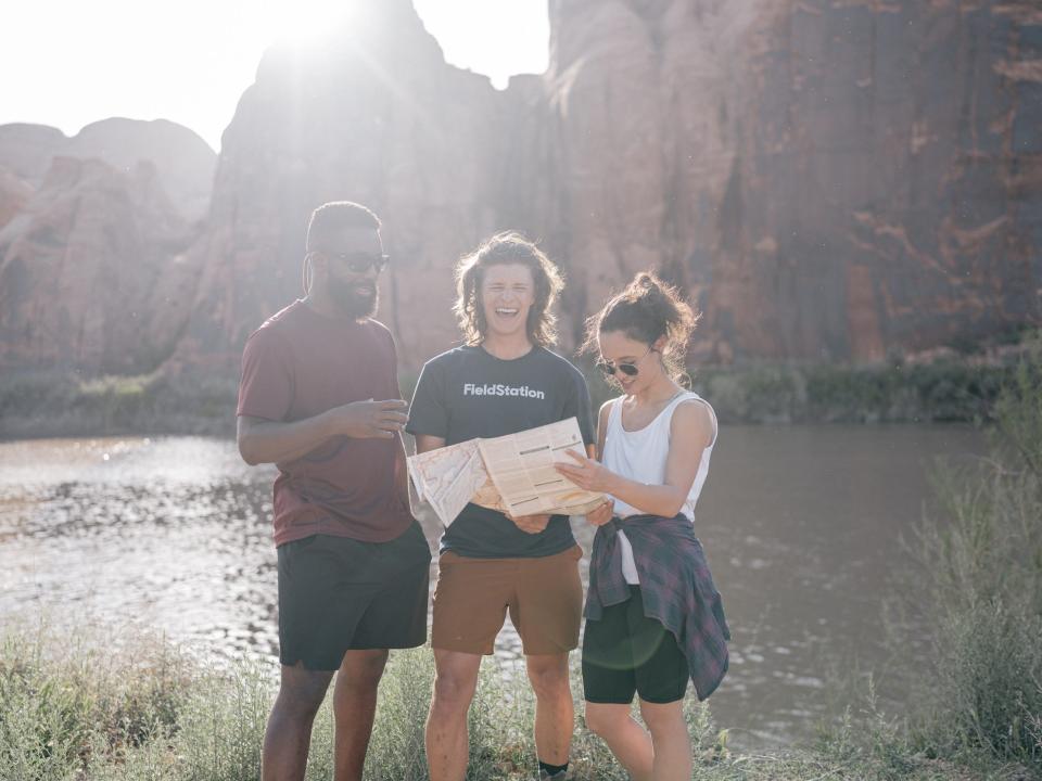 People standing outside in nature holding a map