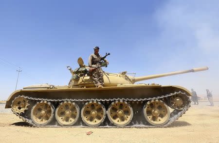 A member of the Kurdish peshmerga troops stands on a tank during an operation against Islamic State militants in Makhmur, on the outskirts of the province of Nineveh August 7, 2014. REUTERS/Stringer