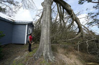 Layla Winbush looks at a fallen tree in front of her damaged home in Lake Charles, La., in the aftermath of Hurricane Laura, Sunday, Aug. 30, 2020. (AP Photo/Gerald Herbert)