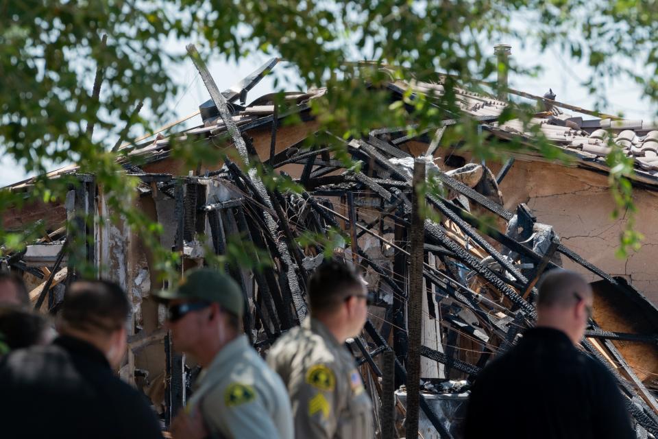 Deputies stand near a destroyed house in the 14900 block of Adalane Court in Victorville on Wednesday, June 29, 2022. Authorities said an explosion occurred at the home, which injured a 40-year-old woman and damaged nearby houses.