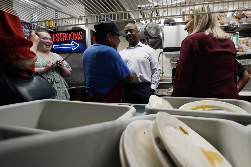 Sen. Tim Scott, R-S.C., talks with a kitchen worker during a visit to the Red Arrow Diner, Thursday, April 13, 2023, in Manchester, N.H. Scott on Wednesday launched an exploratory committee for a 2024 GOP presidential bid, a step that comes just shy of making his campaign official. (AP Photo/Charles Krupa)