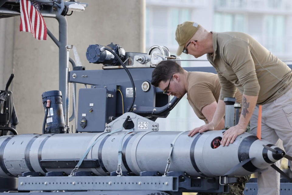 Members of the Navy work on a device on a vessel along the InterCoastal Waterway in North Myrtle Beach, S.C., Tuesday, Feb. 7, 2023. Using underwater drones, warships and inflatable vessels, the Navy is carrying out an extensive operation to gather all of the pieces of the massive Chinese spy balloon a U.S. fighter jet shot down off the coast of South Carolina on Saturday. (AP Photo/Nell Redmond)