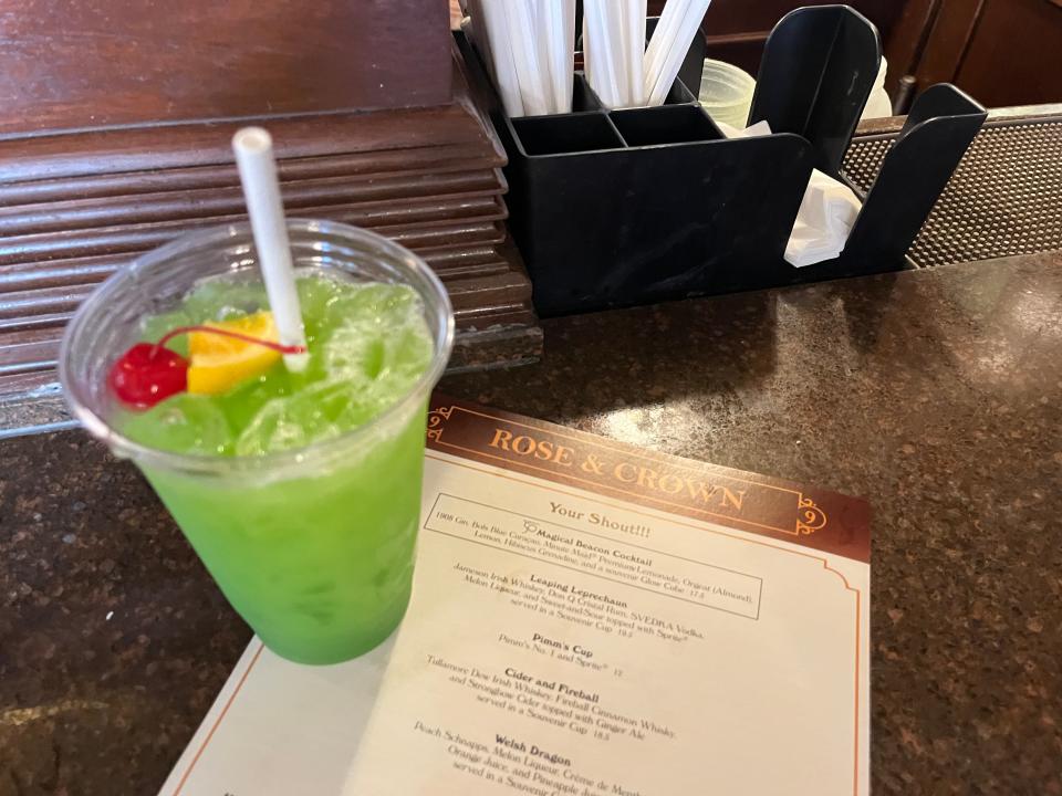 green cocktail resting on the menu for rose and crown pub at epcot