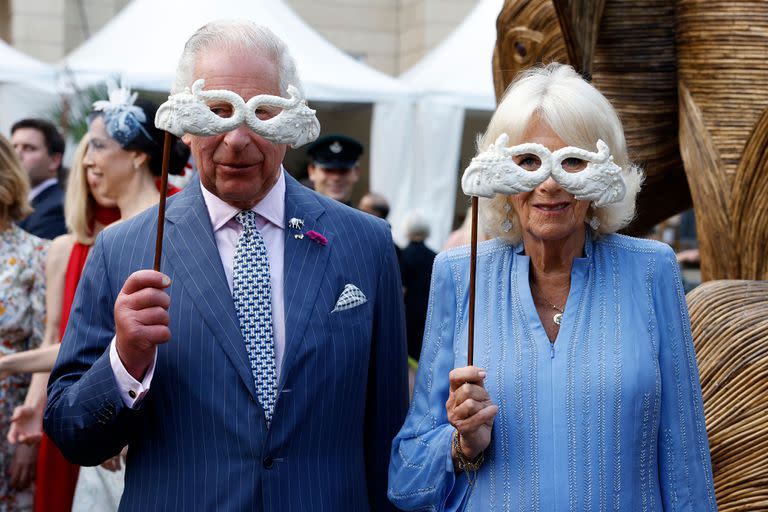 El rey Carlos III de Gran Bretaña y la reina Camilla sostienen máscaras mientras asisten al Animal Ball en Lancaster House en Londres el 28 de junio de 2023.