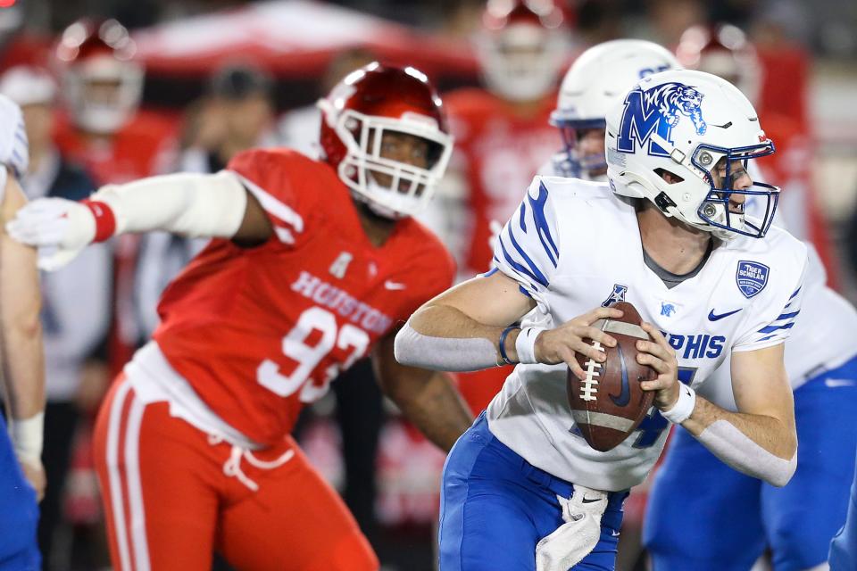 Nov 19, 2021; Houston, Texas, USA;  Memphis Tigers quarterback Seth Henigan (14) rushes against Houston Cougars defensive lineman Atlias Bell (93) in the second quarter at TDECU Stadium.