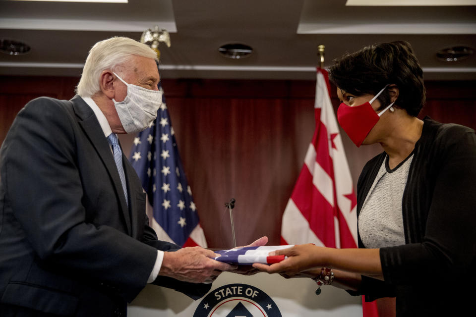 FILE - In this June 16, 2020, file photo District of Columbia Mayor Muriel Bowser, right, presents House Majority Leader Steny Hoyer of Md., left, with a flag with 51 stars on it during a news conference on D.C. statehood on Capitol Hill in Washington. Bowser’s national profile had never been higher, thanks to a Twitter beef with President Donald Trump and a renewed push to turn the nation's capital into the 51st state. (AP Photo/Andrew Harnik, File)