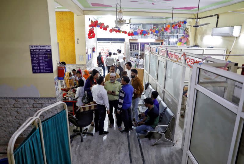 Staff members and volunteers speak in a lobby of Al Hind hospital, where victims are treated following clashes between people demonstrating for and against a new citizenship law in a riot affected area in New Delhi