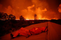 <p>Mark Clawson, 64, rests while watching a lava flow from a neighbor’s roof on the outskirts of Pahoa during ongoing eruptions of the Kilauea Volcano in Hawaii, June 6, 2018. (Photo: Terray Sylvester/Reuters) </p>