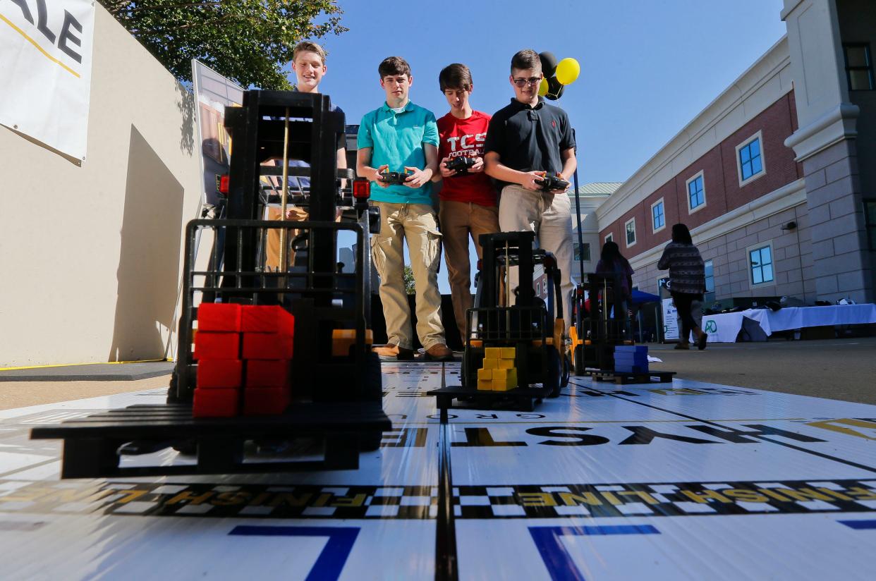 Zach Homan, Jacob Sumner, Daxon Chandler and Timothy Boyce, all students at Tuscaloosa Christian School, race radio controlled forklifts during the West Alabama Worlds of Work at Shelton State Thursday, October 12, 2017. [Staff Photo/Gary Cosby Jr.]