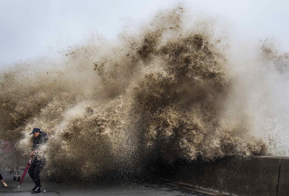 A man dodges tidal waves under the influence of Typhoon Usagi in Hangzhou, Zhejiang province, September 21, 2013. China's National Meteorological Center issued its highest alert, warning that Usagi would bring gales and downpours to southern coastal areas, according to the official Xinhua news agency. Picture taken September 21, 2013. REUTERS/Chance Chan (CHINA - Tags: ENVIRONMENT TPX IMAGES OF THE DAY) CHINA OUT. NO COMMERCIAL OR EDITORIAL SALES IN CHINA