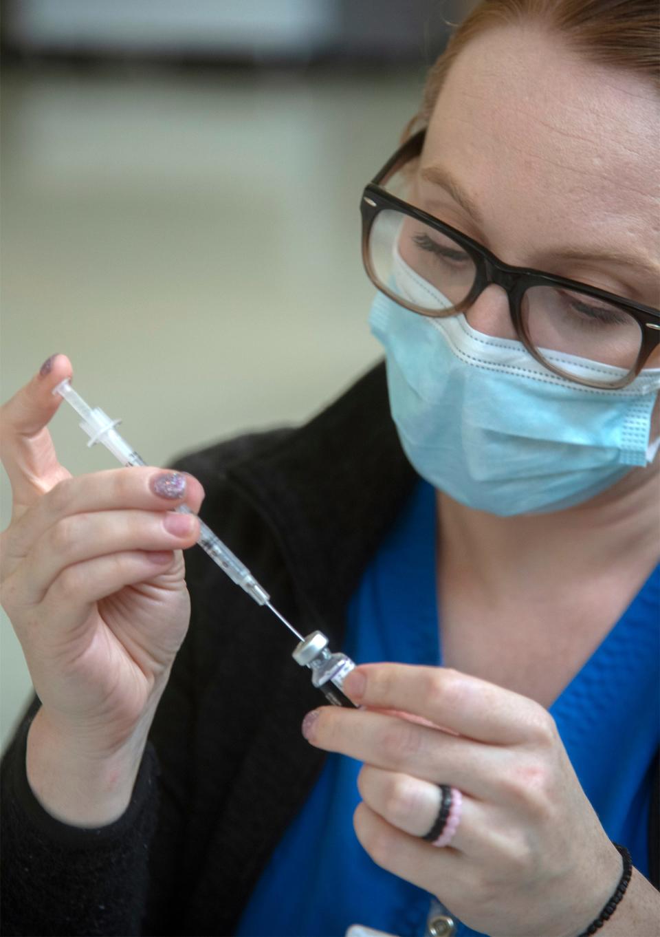 Samantha Sola with Community Medical Centers prepares syringes with the COVID-19 vaccine at a vaccination clinic at Madison elementary School in Stockton. 