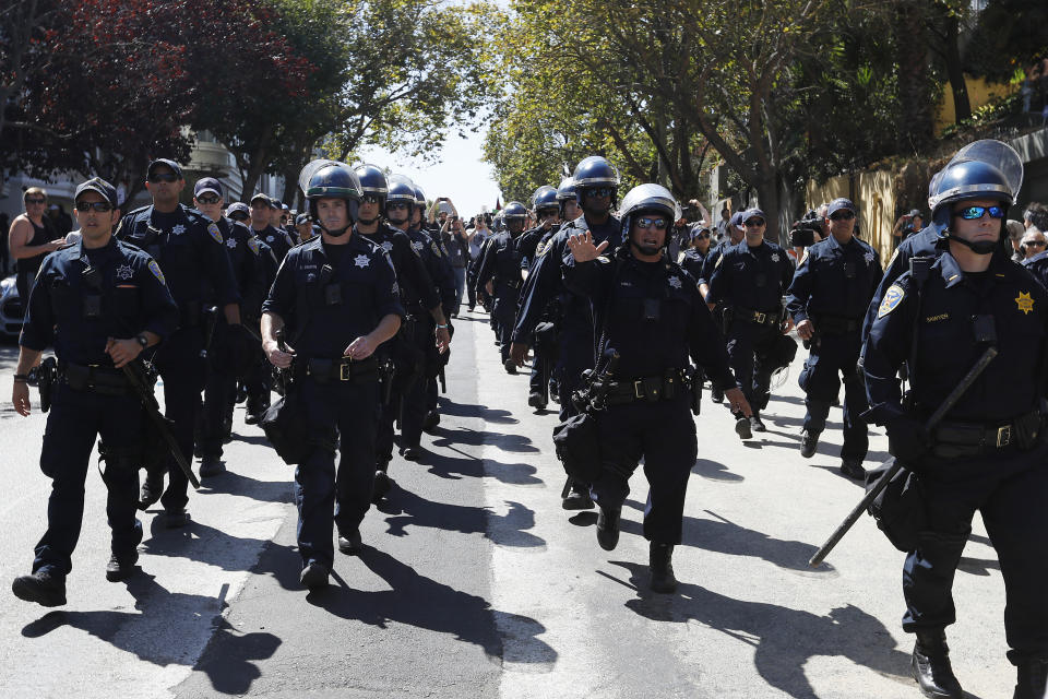 <p>Police officers march toward Alamo Square as demonstrators rally ahead of a news conference by the organizers of the cancelled alt-right Patriot Prayer rally on Aug. 26, 2017 in San Francisco, Calif. Originally planned to be held at Crissy Field, the rally and the subsequent news conference were cancelled by organizers citing safety concerns as various groups were expected to counter demonstrate against the controversial event while city officials continue preparing for any possible unrest. (Photo: Stephen Lam/Getty Images) </p>