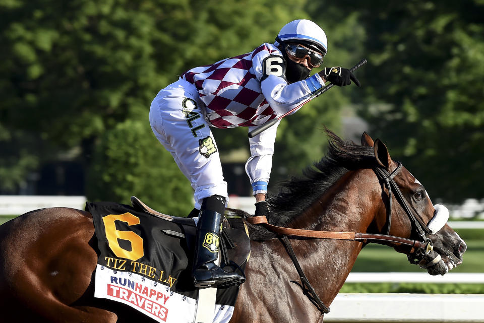 In a photo provided by the NYRA, jockey Manny Franco reacts after crossing the finish line with Tiz the Law to win the Travers Stakes horse race at Saratoga, Saturday, Aug. 8, 2020, in Saratoga Springs, N.Y. (Chris Rahayel/NYRA via AP)