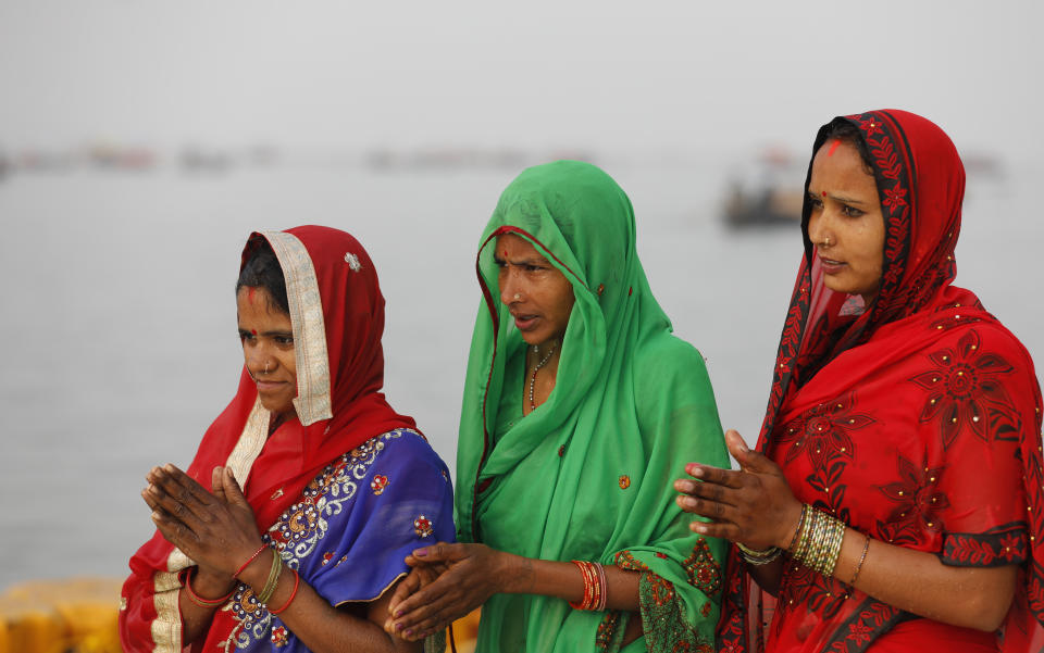 Hindu devotees offer prayers while taking a ritualistic bath in the Sangam, the confluence of three rivers — the Ganges, the Yamuna and the mythical Saraswati, during Makar Sankranti festival that falls during the annual traditional fair of Magh Mela festival, one of the most sacred pilgrimages in Hinduism, in Prayagraj, India. Friday, Jan. 14, 2022. Tens of thousands of devout Hindus, led by heads of monasteries and ash-smeared ascetics, took a holy dip into the frigid waters on Friday despite rising COVID-19 infections in the country. (AP Photo/Rajesh Kumar Singh)