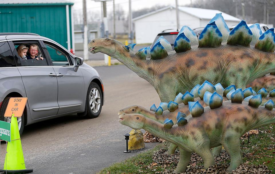 Children enjoy a Stegosaurus display during Jurassic Wonder, a robotic dinosaur display, at the Ashland County Fairgrounds.