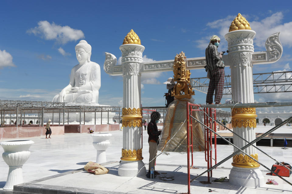 Laborers work near the sitting Maravijaya Buddha marble statue, Friday, July 21, 2023, in Naypyitaw, Myanmar. The Maravijaya Buddha statue is said to be the world’s highest sitting marble Buddha image according to local media. (AP Photo/Aung Shine Oo)