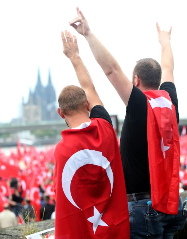 Waving the Turkish flag and chanting "Turkey", the demonstrators turned the rally site next to the River Rhine in Cologne into a sea of red as they began the demonstration by singing the Turkish and German national anthems