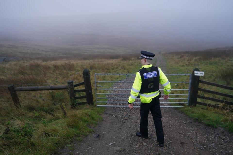 A policeman guards the area around the dig site on Saddleworth Moor.