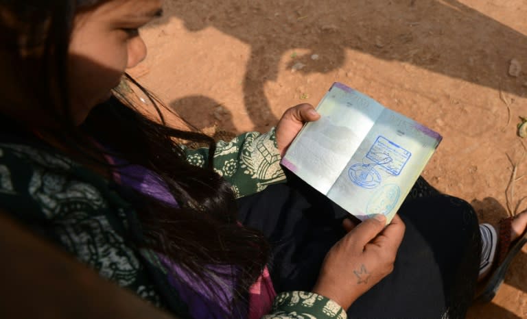 Nepalese migrant worker Sunita Magar, who was trafficked to Syria, holding her passport at home in Dhadhing district, some 100 km west of Kathmandu