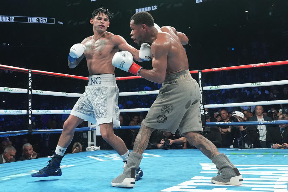 Ryan Garcia, left, punches Devin Haney during the 12th round of a super lightweight boxing bout early Sunday, April 21, 2024, in New York. (AP Photo/Frank Franklin II)